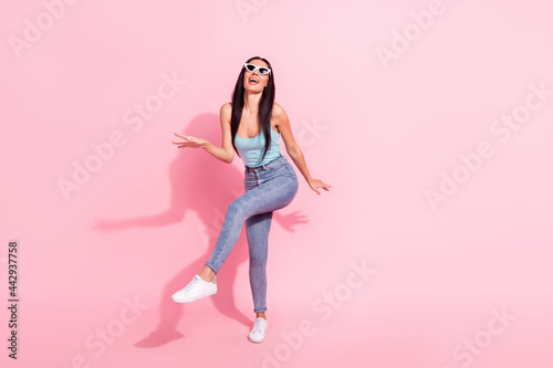 Full length body size photo woman in sunglass dancing at party isolated pastel pink color background