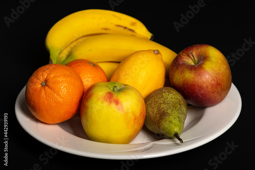 Fruit bowl with bananas  oranges  apples  lemon and pear