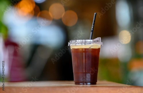 Cup of ice blackcoffee with light bokeh background