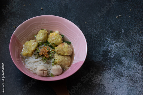 Pork wonton noodles, white vermicelli on a black background table