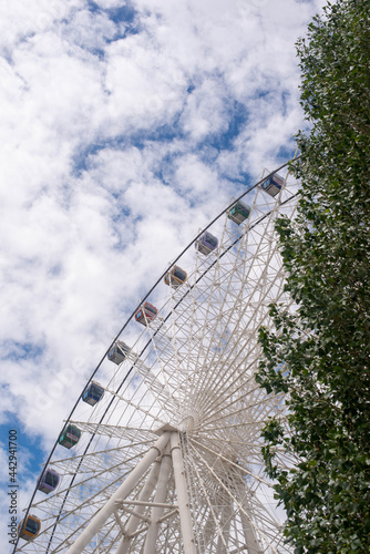 a big ferris wheel with colored cabins in the park