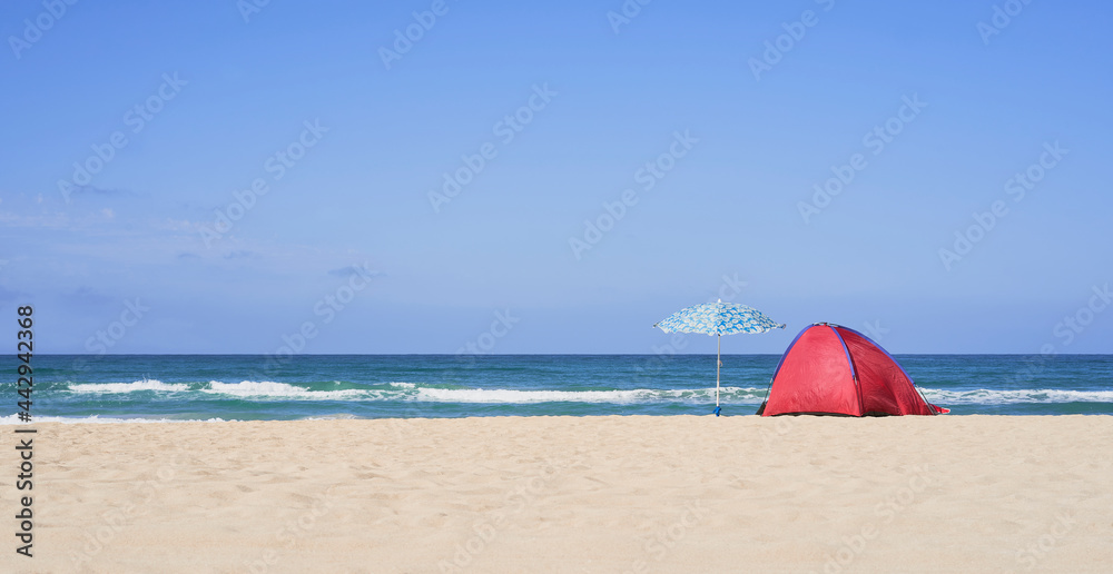 Summer concept. Two umbrellas, beach and blue sea on a beautiful sunny day
