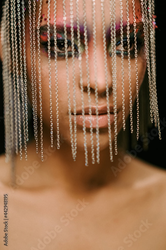 Stylish ethnic woman in creative African headpiece in studio