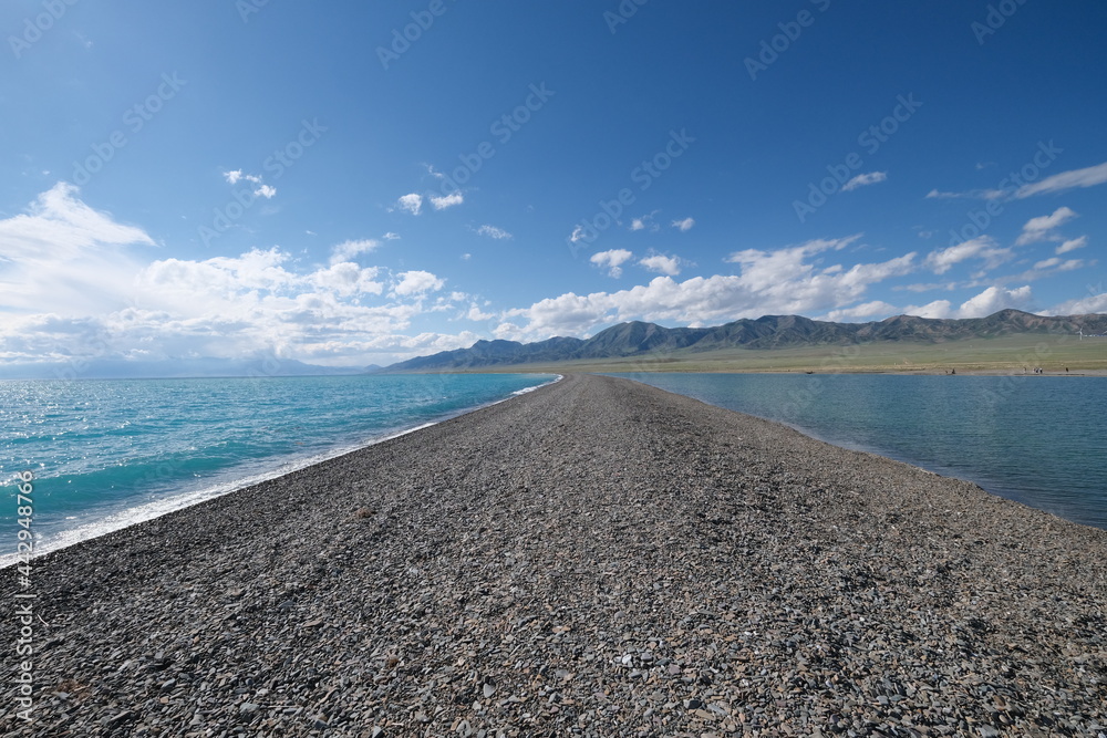empty road land ground between beautiful blue sea water on sunny day. At Sayram Lake in Xinjiang China