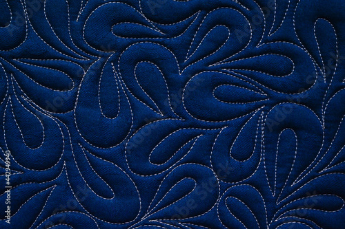Close up texture of quilting by free-motion machine technique. on dark blue clothes Background