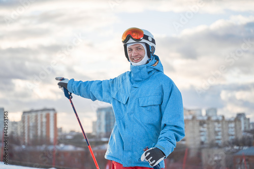 Cheerful skier on snowy hill slope photo
