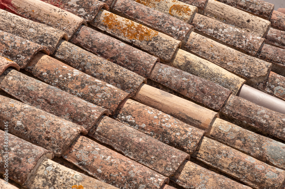 image of a portion of the roof with old tiles deteriorated by time image of a portion of the roof with old tiles deteriorated by time