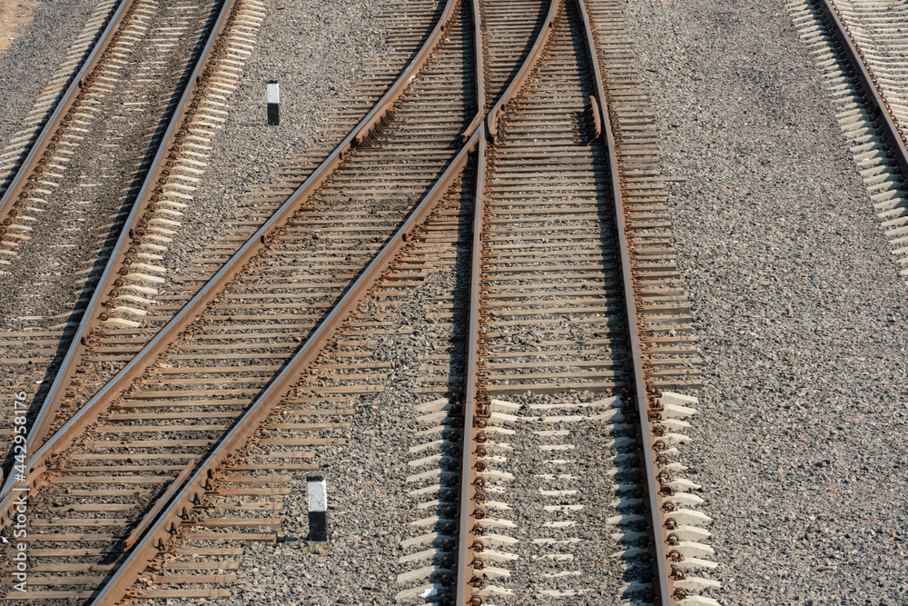 View of the railway from above. New modern railway with concrete piles and rubble. The intersection of rail tracks on the same level. Three rows of railway tracks