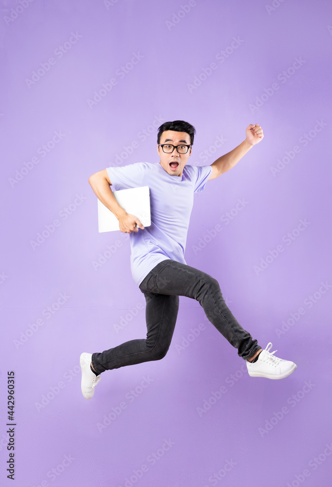 Portrait of a jumping asian man, isolated on purple background