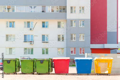 Different Colored Bins For Collection Of Recycle Materials stand next to regular containers for mixed waste