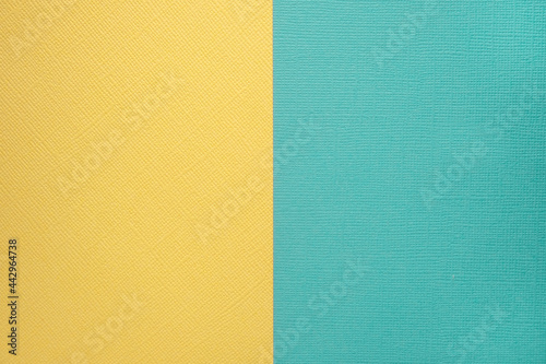 Two colored papers with a blue and yellow overlay on the floor. they divide half of the image. Dual background, flat lay. High quality photo
