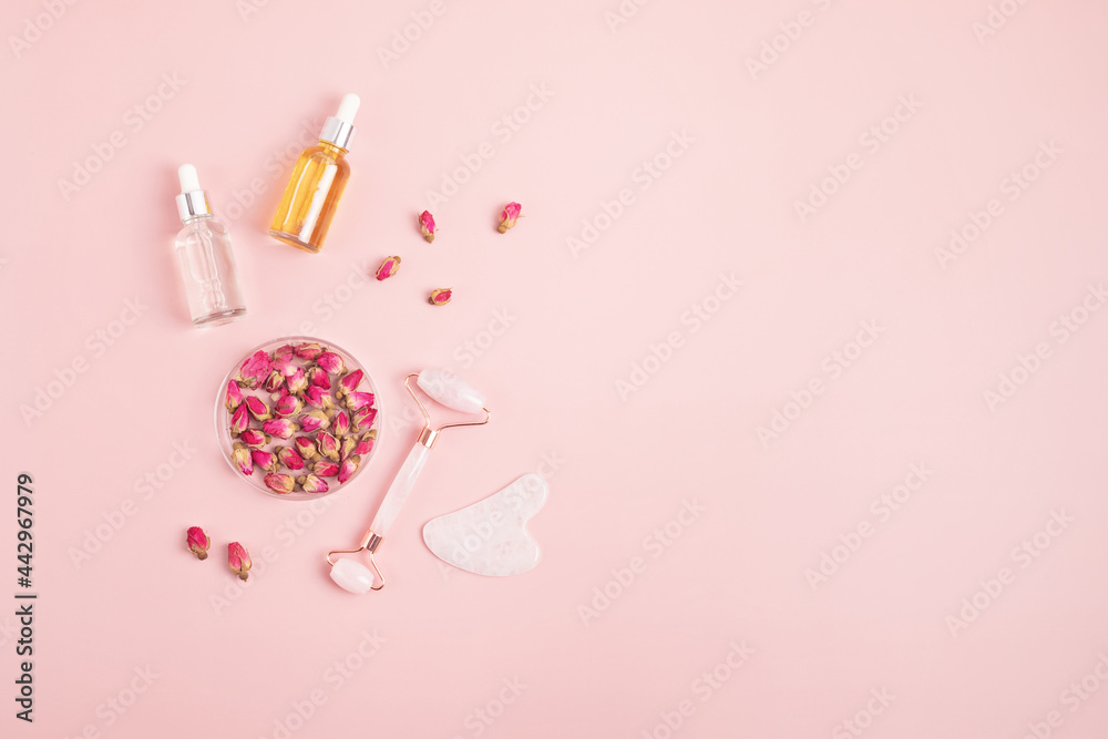 Rose quartz face roller, gua sha stone, essential oil and dry roses