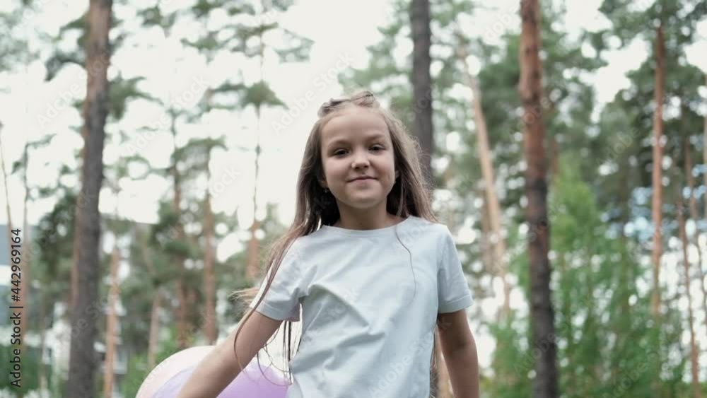 pretty preschool girl having fun playing with hot air balloons outdoors. hollidays, party, birthday, celebration. happy children. slow motion. pretty preschool girl having fun playing with hot air balloons outdoors. hollidays, party, birthday, celebration. happy children. slow motion.