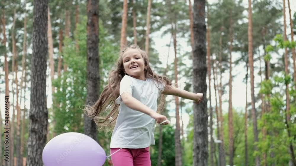 pretty preschool girl having fun playing with hot air balloons outdoors. hollidays, party, birthday, celebration. happy children. slow motion. pretty preschool girl having fun playing with hot air balloons outdoors. hollidays, party, birthday, celebration. happy children. slow motion.