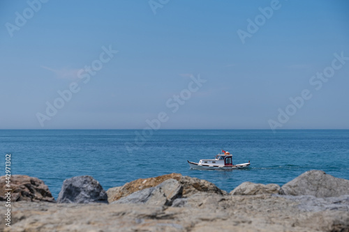 small fishing boat in the sea, rocky coast