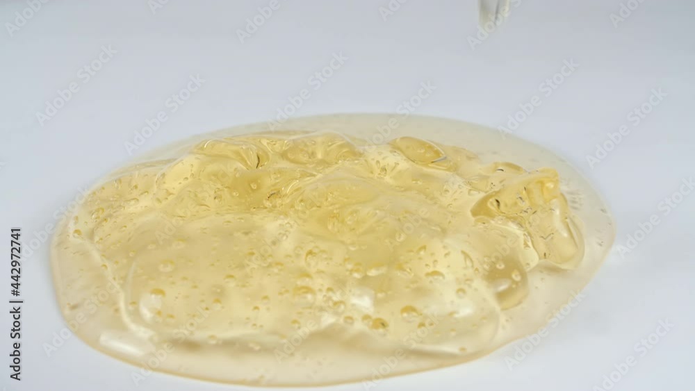 Slow Motion Shot of Pouring Oil Liquid Yellow Golden Hue. Cream Gel, Cosmetic Texture with Bubbles. Macro Shot. High quality 4k footage Slow Motion Shot of Pouring Oil Liquid Yellow Golden Hue. Cream Gel, Cosmetic Texture with Bubbles. Macro Shot. High quality 4k footage