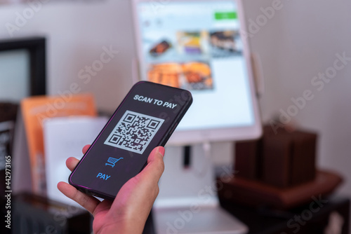 People's hands are using smartphones to scan QR codes.
