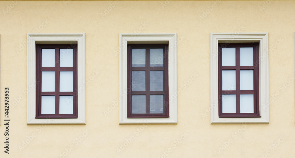 Three windows on wall of house.