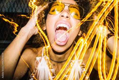Alluring young African American female singing with expression in nightclub photo
