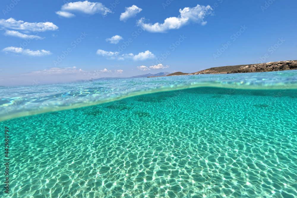 Split underwater photo of exotic island paradise bay with crystal clear emerald sandy beach