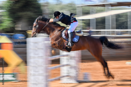 Rider on horse jumping over a hurdle during the equestrian event 