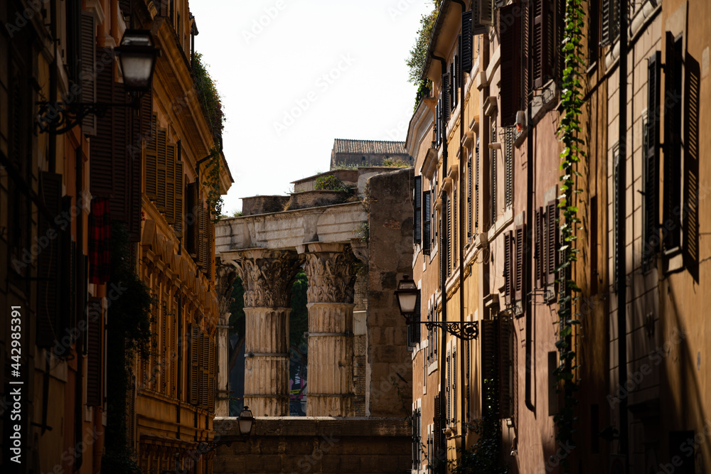 The narrow ginger colour street in the neighborhood of Coliseum.  the old building made of ginger color stone in Rome