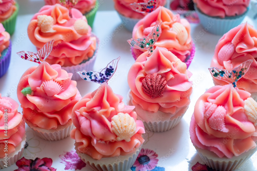 macro shot of colorful cupcake bakery soaps with pink orange icing with small shells and transparent resin mermaid tail made for home industry macro shot of colorful cupcake bakery soaps with pink orange icing with small shells and transparent resin mermaid tail made for home industry