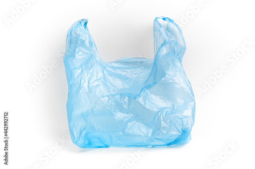 Blue plastic bag with handles on a white background. The used plastic bag may be recyclable. Recycling of plastic waste into pellets as a business.