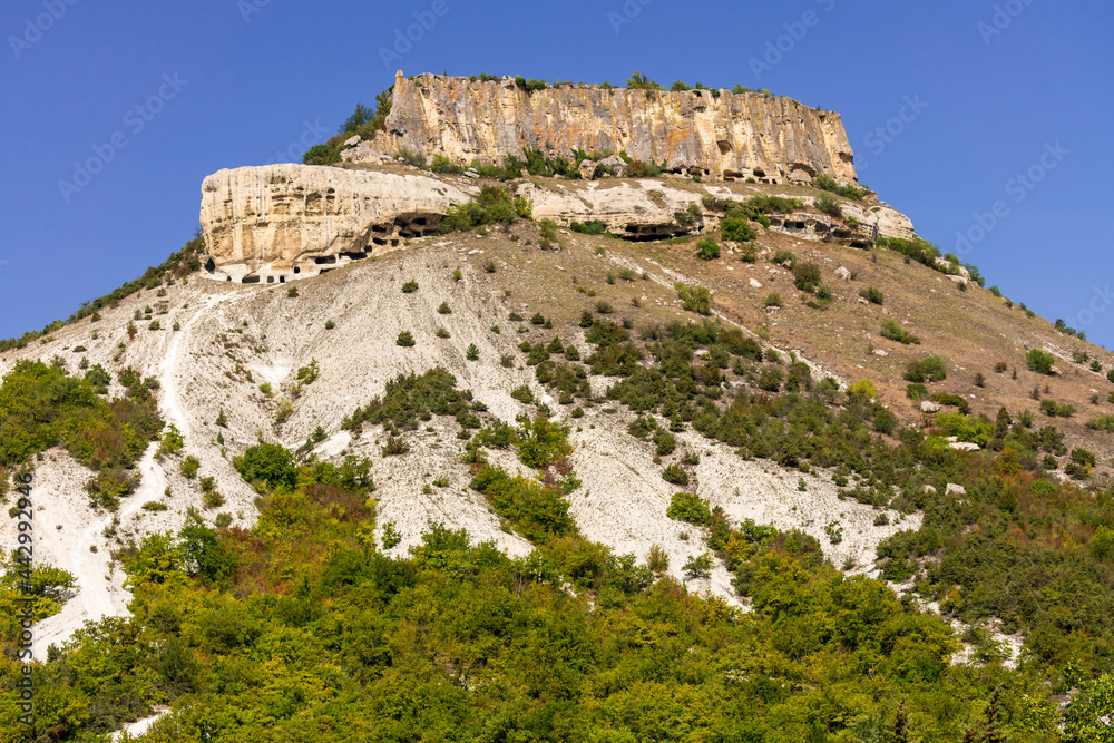 Tepe-Kermen is an ancient cave town in Crimea. Scenic sunny day landscape.