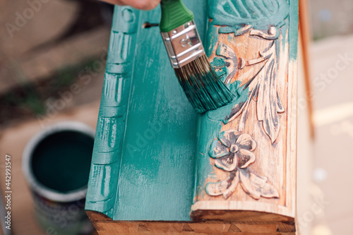 the process of painting a wooden dresser drawer or table with a floral pattern outdoors, an eco-friendly re-use business. 