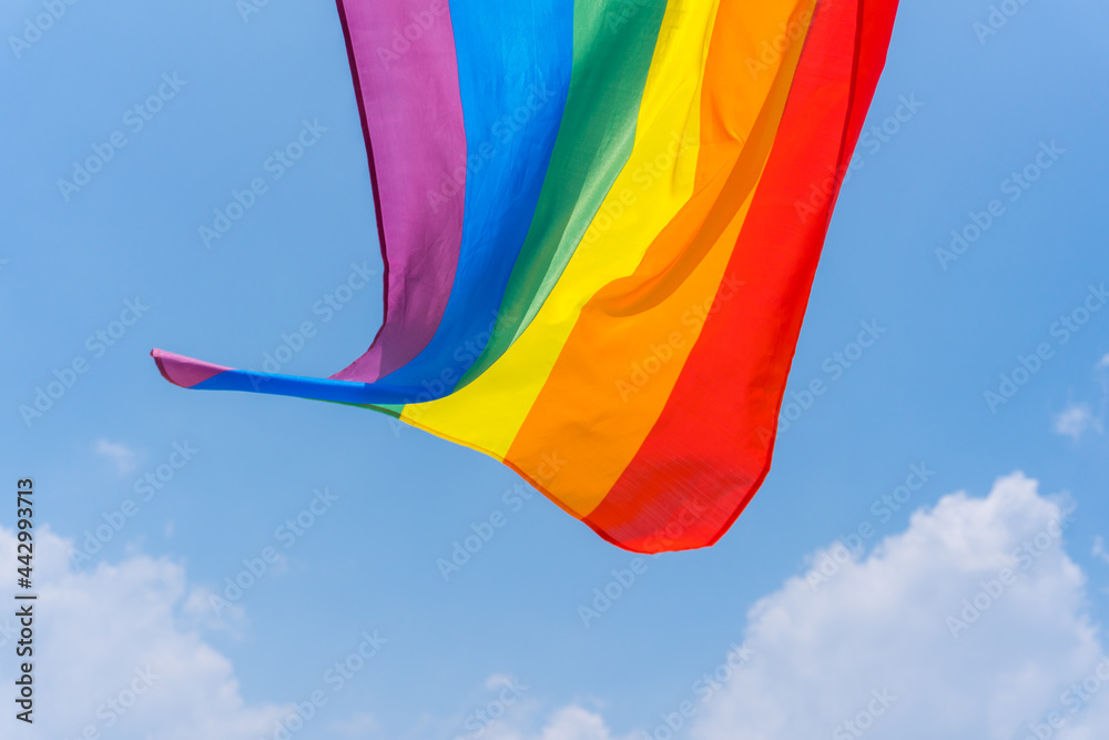 A closeup shot of a rainbow flag fluttering on a wind A closeup shot of a rainbow flag fluttering on a wind