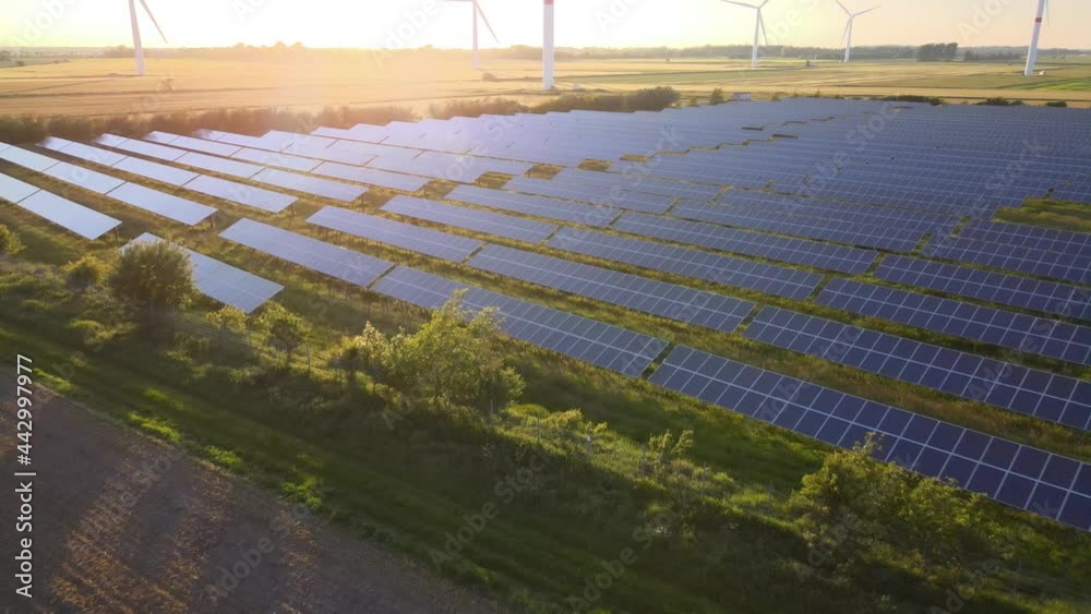 Windkraftanlage mit Solarpark bei Sonnenuntergang im Sommer Windkraftanlage mit Solarpark bei Sonnenuntergang im Sommer