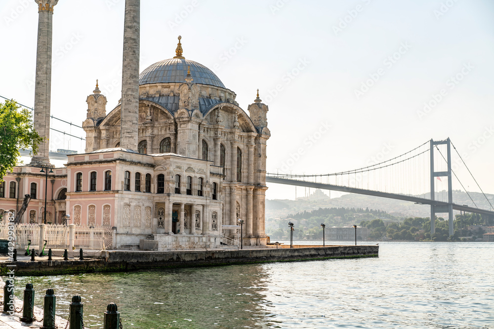 Beautiful Istanbul landscape. Sunrise near Bosphorus bridge (aka: 15 July Martyrs Bridge. Turkish: 15 Temmuz Sehitler Koprusu). Grand Imperial Mosque of Sultan Abdulmecid in Ortakoy, Turkey.