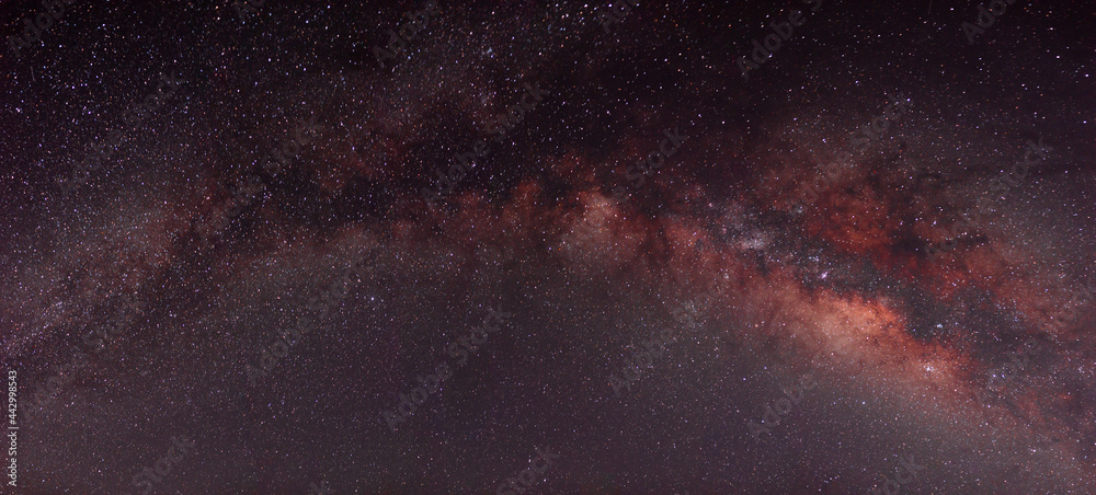 Fototapeta premium Milky way in panoramic night sky and stars on dark background with noise and grain Photo taken with long exposure and white balance selected.