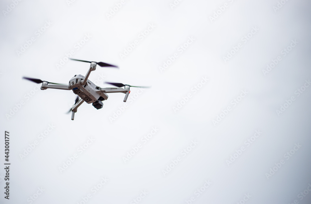 Modern drone with video camera in the air against the background of the sky Modern drone with video camera in the air against the background of the sky