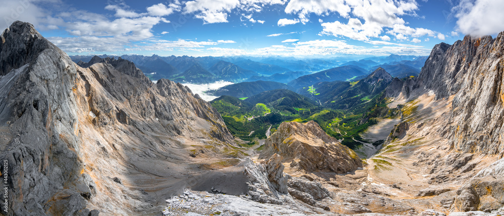 Panorama shot from Skywalk, or Hunerkogel, in the Hoher Dachstein area. Broad and vast Alpine scenery on a sunny summer day with blue sky and soft clouds.