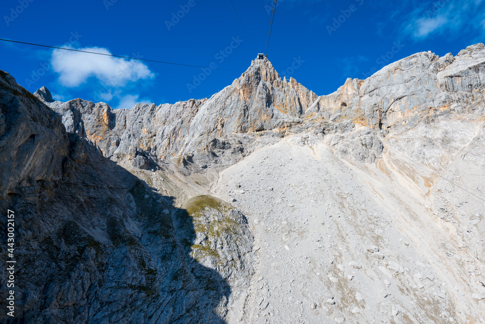 Low angle shot of Cable way up to Hunerkogel in Austrian Alps, right next to Schladming Glacier and under Hoher Dachstein massif, on a sunny summer day.