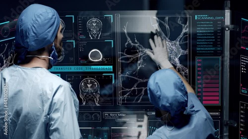Professional doctors analyzing patient's medical MRI diagnosis by checking on a large glass screen with futuristic holograms. Concept of: medicine, doctors, future, holographic, brain scan
