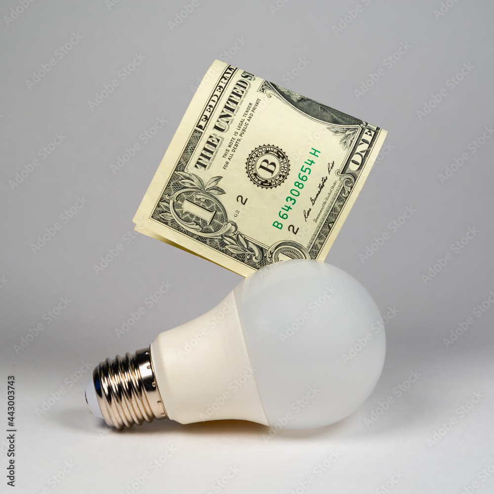 Energy saving light bulb and money (US dollar), money economy concept. Energy saving light bulb and money (US dollar), money economy concept.