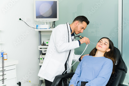 Handsome doctor examining an ear infection