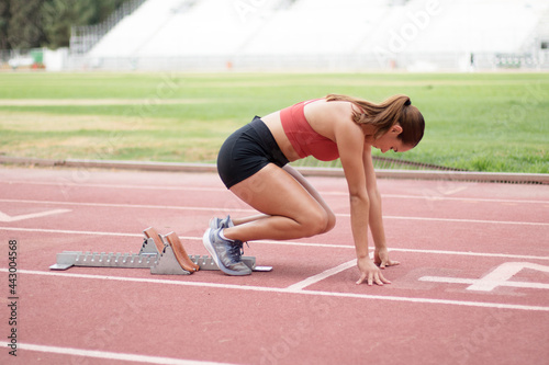 young woman in starter preparing to sprinting