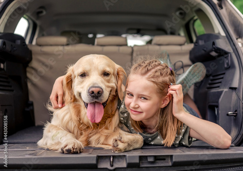 Preteen girl with golden retriever dog in the car © tan4ikk