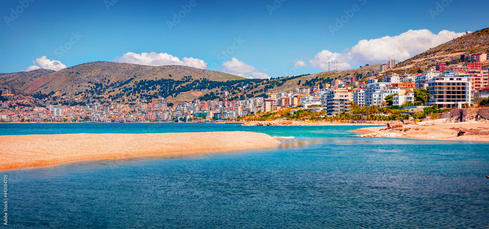 Azure river flowing in the sea. Panoramic spring cityscape of Saranda port. Amazing Ioninan seascape. Colorful morning scene of Albania, Europe. Traveling concept background.