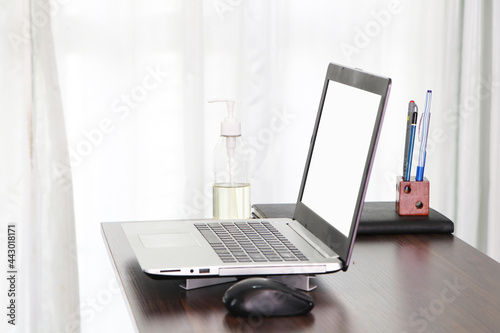 Office equipment Communicates internet with customer home. Alcohol, pen, pencil, book on desk.  remote work, Computer white screen. Work from home for quarantine times in Coronavirus Covid-19  © Thepporn