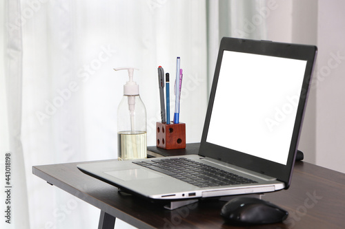 Office equipment Communicates internet with customer home. Alcohol, pen, pencil, book on desk. remote work, on modern laptop at home. Work from home. Computer white screen.