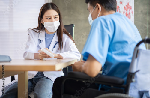 Young asian woman doctor encouragement and supportive to cansor patient after consult and examine in clinic hospital health ideas concept. Problem talk at medical checkup visit with wheelchair .