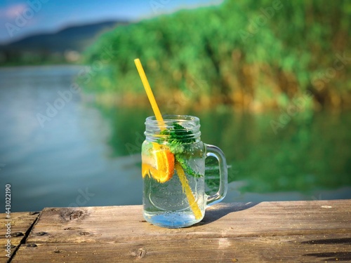 Lemonade jar placed on a wooden pontoon near the lake