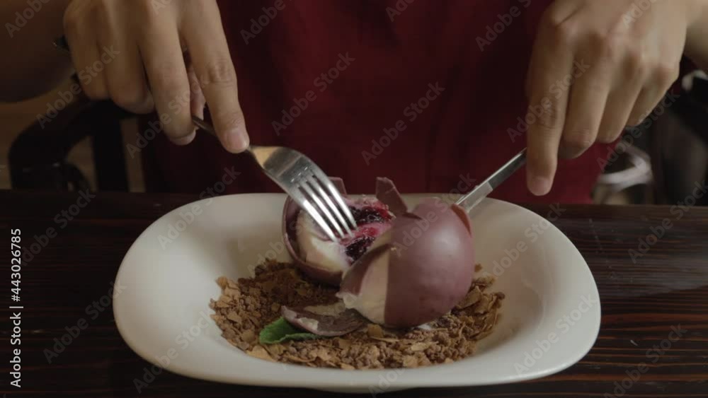 Cutting a chocolate-covered round cheesecake with a fork and knife. Take bite of cheesecake. Cutting a chocolate-covered round cheesecake with a fork and knife. Take bite of cheesecake.