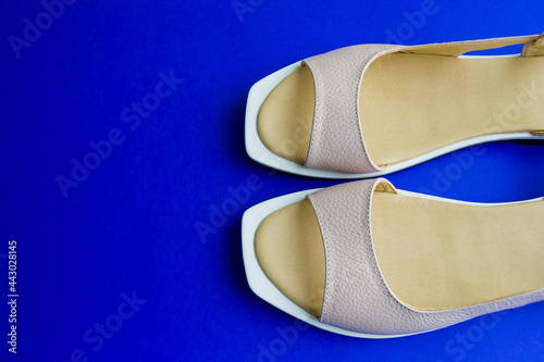 women's shoes of beige color on a blue background. the shoes are removed from the top