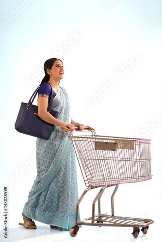 Canvastavla A young woman walking with a trolley.